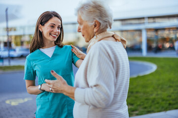 Caring Nurse Interacting with Elderly Woman Outdoors