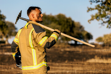 Firefighter with tool ready for action in a forest setting