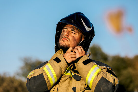 Firefighter adjusting helmet during forest fire operation