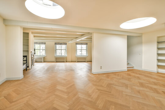 Spacious empty room with hardwood floors and natural light