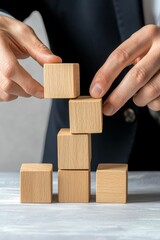 Hands methodically arranging wooden blocks, conveying precision, strategy, and organizational skills in achieving business goals