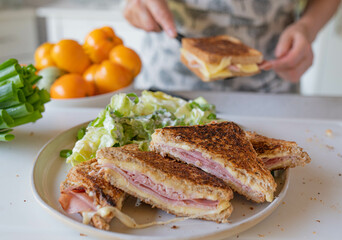 Woman preparing homemade ham and cheese sandwiches in the kitchen