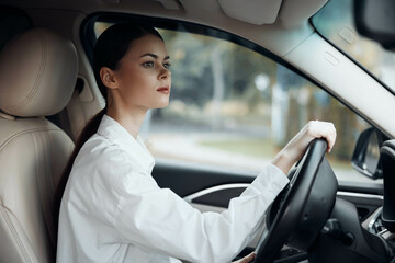 A woman confidently drives a car, both hands on the steering wheel, and gazes directly into the camera, exuding a sense of control and awareness, perfect for illustrating safe driving or female