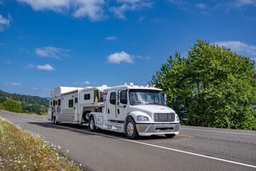 Specialized low profile four doors extended cab white big rig semi truck tractor transporting...