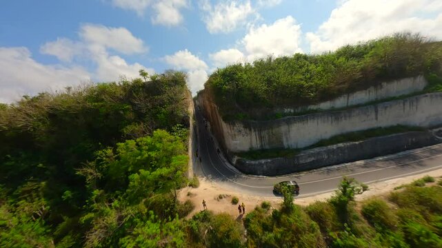 FPV flight over the road in limestone cliffs near Batu Barak beach in Bali, Indonesia