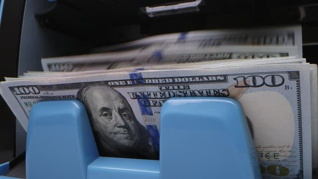 ATM dispenses cash during a busy afternoon in downtown, showcasing bills being withdrawn