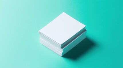 A stack of blank white paper on a teal background, suggesting potential for creativity.