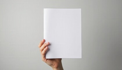 Fototapeta premium Hand holding a blank white binder, isolated on a soft gray background