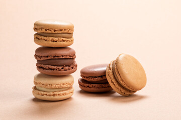 Variety of french macarons pastry on light brown background