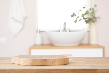 Wooden table with pedestal in blur bathroom for bathing and spa product display
