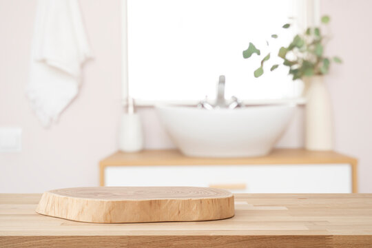 Wooden table with pedestal in blur bathroom for bathing and spa product display