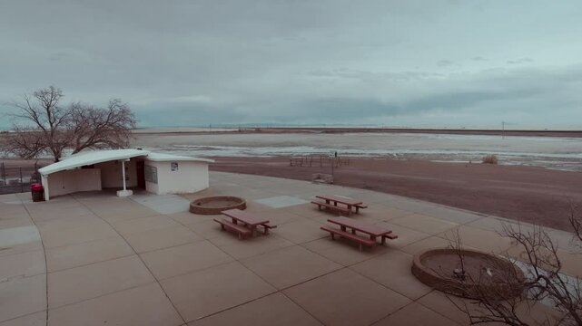 Empty benches, resting place without people next to a white desert. Abandoned place, liminal space.
