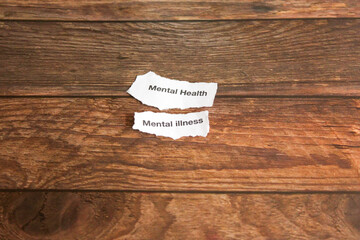 Mental health disorders on strips of paper on wooden table. 