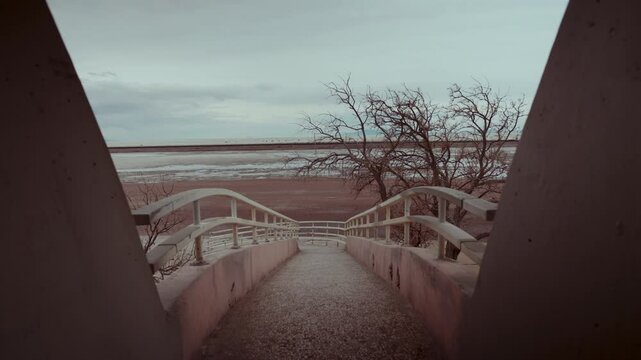 Empty concrete bridge towards a white desert.