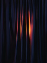 Fototapeta premium A close-up shot of black velvet curtains draped dramatically, revealing a warm, orange glow from behind. The image evokes a sense of anticipation, mystery, and the impending unveiling of something spe