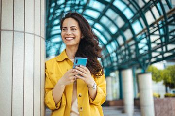 Smiling Woman Using Smartphone in Urban Setting