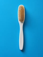 White plastic hairbrush with bristles made of natural wood, standing upright on an isolated blue background