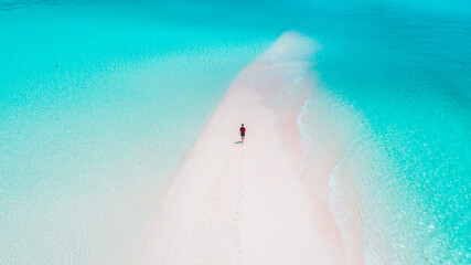 Aerial view of a tropical white sandbank with turquoise waters in the Maldives, perfect summer holiday setting.