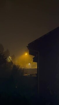 Escena lluvia en d&iacute;a de tormenta con rayos, copiosa, de noche, visto desde una ventana, fondo con la silueta de chalets de fondo &aacute;rboles y farolas