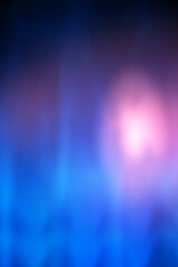 A blurry blue and purple background with a pinkish light in the center