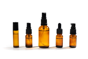 Amber bottles with facial liquid and a linen towel on white table