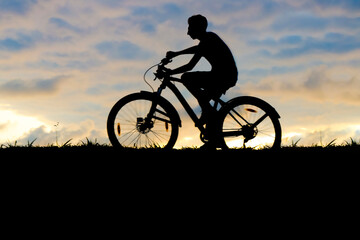 Obraz premium Silhouette of 1 one man ride a bicycle on cloudy sunset sky background. young male riding without hands. alone black of male cycling on horizon line. one guy riding on the hill. sun set sky at sunset