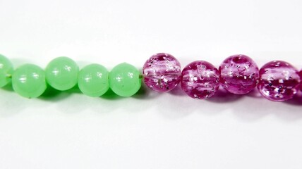 Collana di perline di plastica colorate su sfondo bianco.