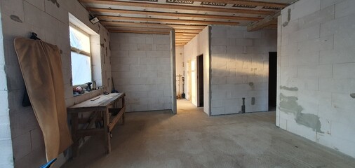 Photo of the inside of a house under construction. The wall material is gas block, the roof is wooden. High quality photo