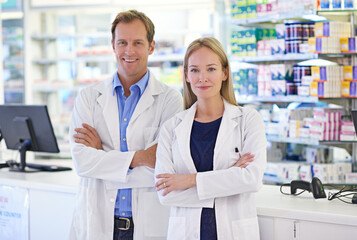 Pharmacist, man and woman in portrait with confidence, smile and prescription drugs in clinic. Pharmacy, help and healthcare team with arms crossed, medicine and pills for medical service at counter