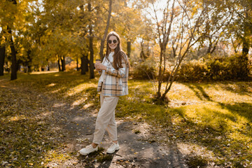 attractive young woman walking in autumn wearing jacket