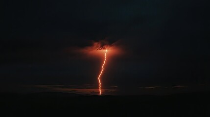 Obraz premium A single, intense lightning bolt striking down from the night sky, creating a stark contrast against the dark backdrop.
