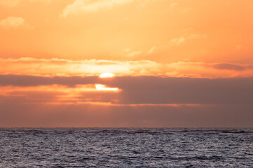 Golden sun sunrise sunset, over ocean sea water, clouds sky horizon, day daylight