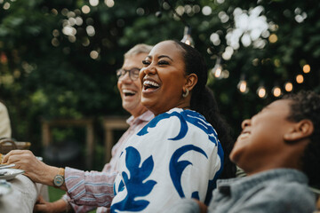 Cheerful woman having fun with male family members at social gathering