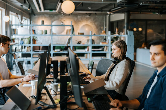 Young male and female programmer working while sitting at desk in office