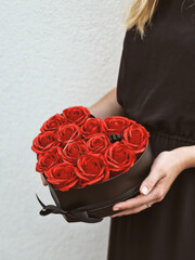 Młoda dziewczyna trzyma w dłoniach piękne czerwone róże mydlane, które wyglądają jak prawdziwe kwiaty. Ich delikatność i żywe kolory dodają zdjęciu elegancji i romantycznego charakteru.  © Adam