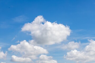 Fluffy White Clouds in Bright Blue Sky Daytime Scene