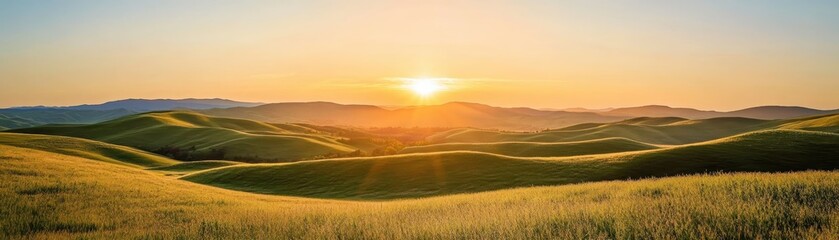 Obraz premium Scenic sunset over rolling hills with golden grass, capturing the serene beauty of nature and tranquility of the countryside landscape.