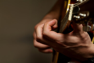 Man's hand playing guitar, close-up
