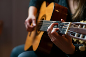 Obraz premium Woman's hand playing guitar, close-up