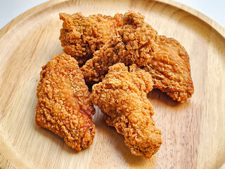 group of fried chicken wings arranged on wooden plate. side view