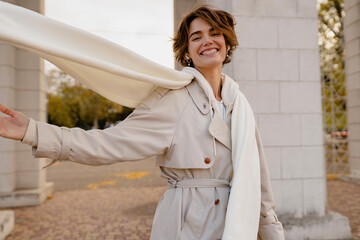 pretty smiling woman walking in park in winter clothes
