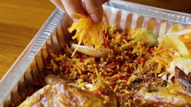 eating chicken kabsah with hand, mandi rice with pickle