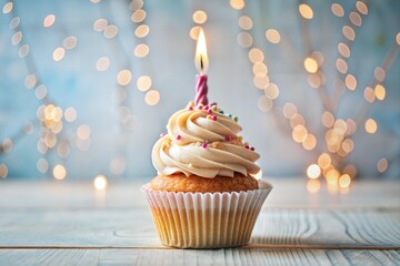 Beautiful cupcake with swirl frosting and lit candle for birthday celebration