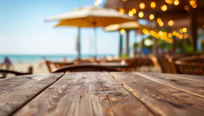 Wooden table and blur beach cafes background with bokeh lights.