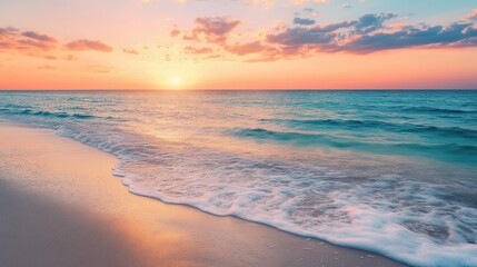 Fototapeta premium Serene beach with gentle waves and a colorful sunset, evoking relaxation and beauty.