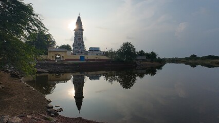 Serene sunset at the Hindu temple reflecting in the calm waters at dusk