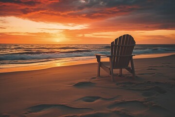 A tranquil beach scene featuring a wooden chair against a vibrant sunset, creating a serene atmosphere for relaxation.