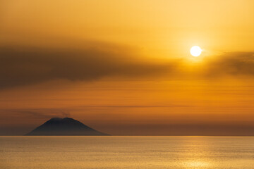 Fototapeta premium sunset on the sea, in front of the volcano, Italy