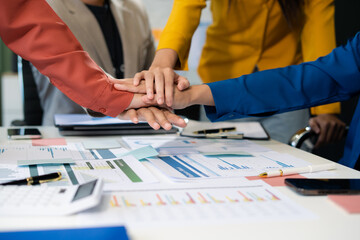 Close up business people holding each others wrists, join hands together, support and unity, team strength and power, colleagues involved in team building activity.