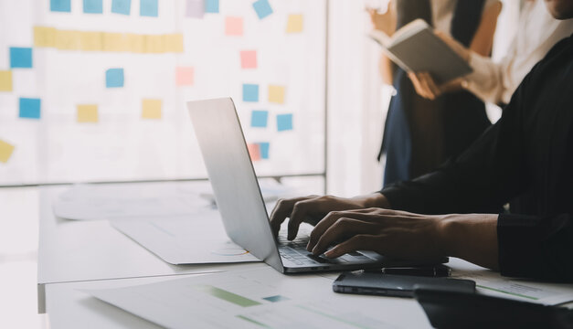 Financial analysts analyze business financial reports on a digital tablet planning investment project during a discussion at a meeting of corporate showing the results of their successful teamwork.